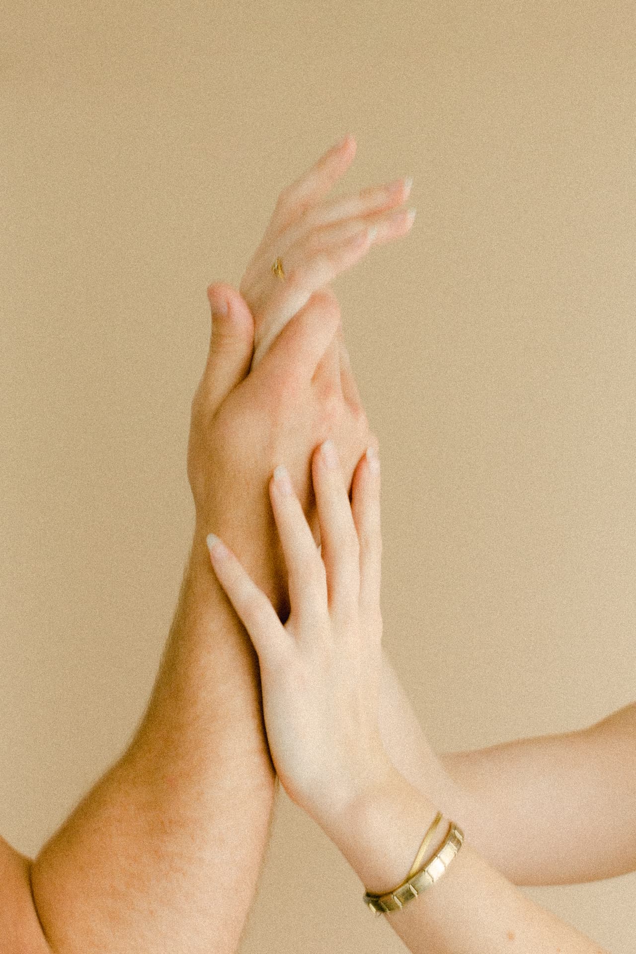 One hand resting supportively over another